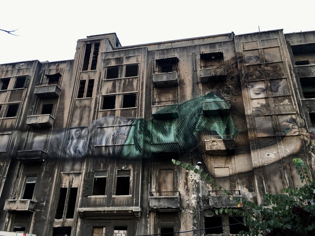 Street Art, kid playing with electronics, building in Bachoura, Graffiti