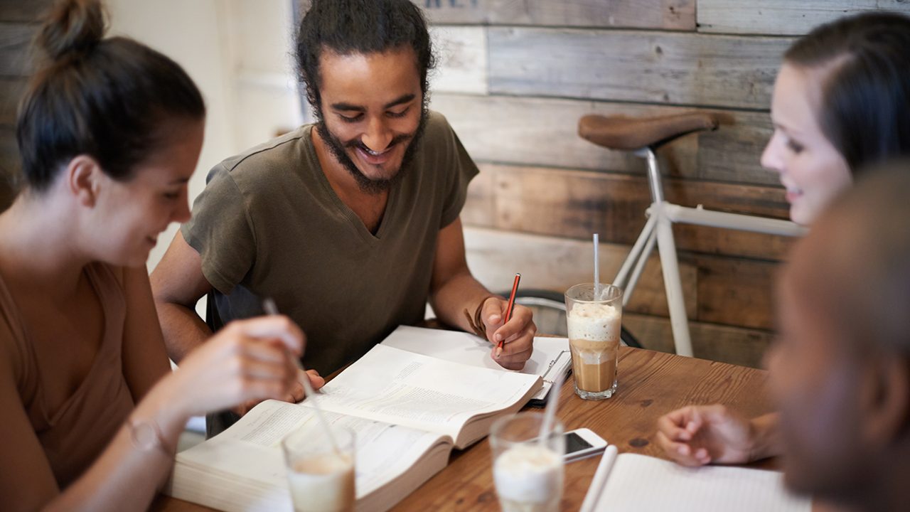 Cropped shot a group of friends studying together at a coffee shop